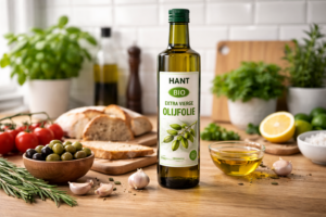 HANT BIO extra vierge olijfolie in glazen fles op een keukenaanrecht met verse ingrediënten