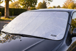 R2B zonnescherm voor auto voorruit geplaatst op geparkeerde auto tegen zon en warmte